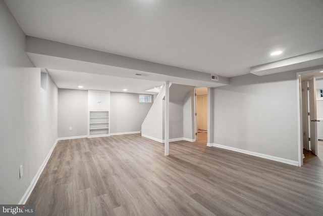 finished below grade area with baseboards, visible vents, wood finished floors, and recessed lighting