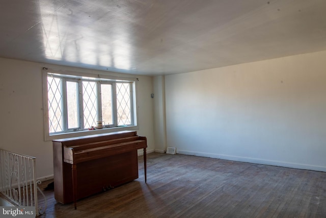 spare room with wood finished floors and baseboards