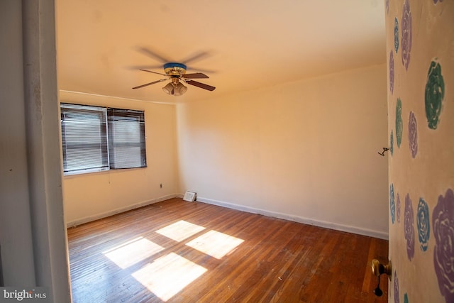 empty room with a ceiling fan, baseboards, and wood finished floors