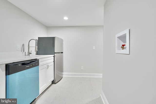 kitchen with baseboards, dishwasher, light countertops, light floors, and white cabinetry