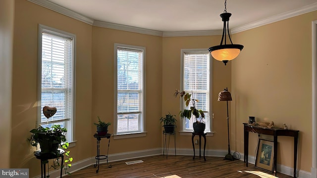 interior space featuring ornamental molding, wood finished floors, visible vents, and baseboards