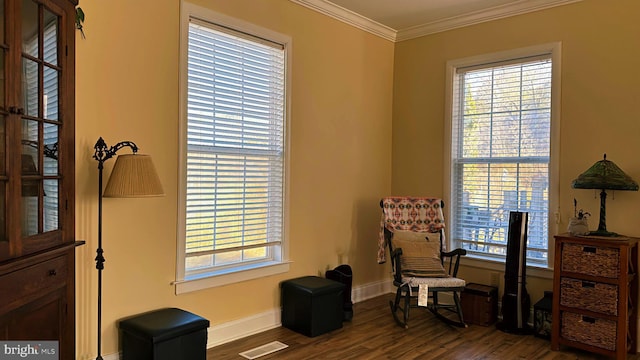 office area featuring plenty of natural light, wood finished floors, visible vents, and crown molding