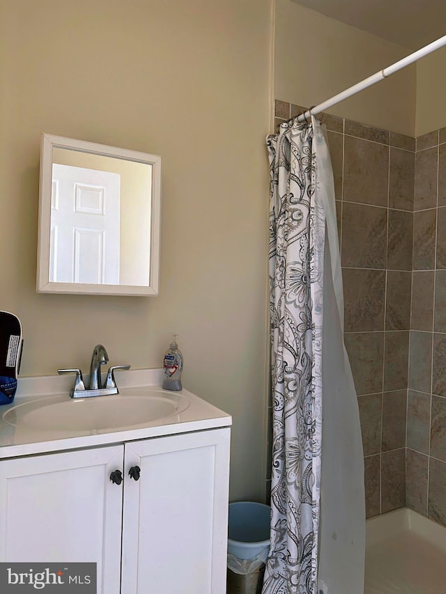 bathroom featuring a tile shower and vanity