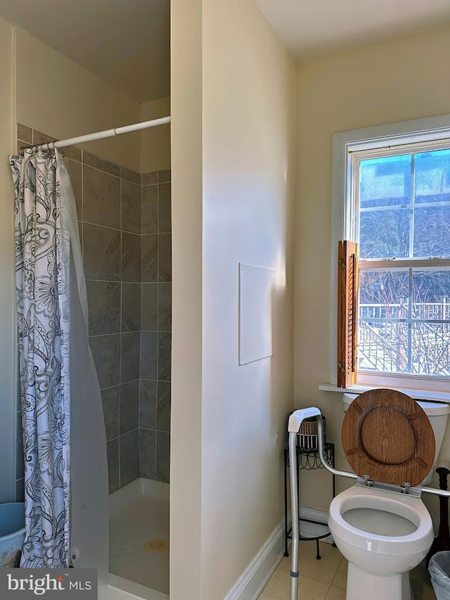 full bath featuring tile patterned flooring, a shower stall, toilet, and baseboards