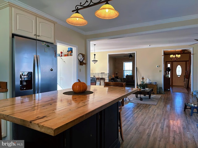 kitchen featuring butcher block counters, hanging light fixtures, ornamental molding, cream cabinetry, and stainless steel refrigerator with ice dispenser