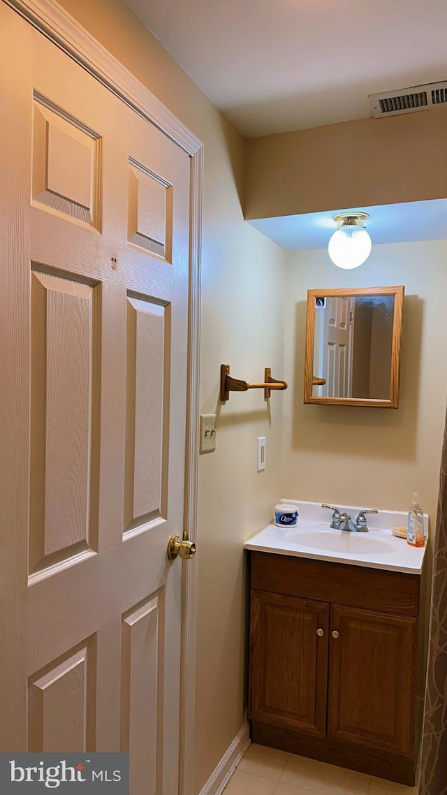 bathroom featuring visible vents, vanity, and baseboards