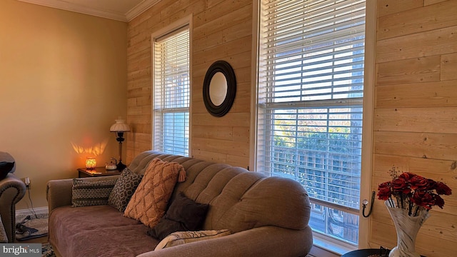 living room featuring wood walls and crown molding