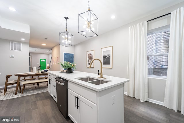 kitchen featuring pendant lighting, a center island with sink, visible vents, white cabinetry, and a sink