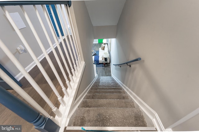 stairs with baseboards and wood finished floors