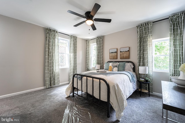 bedroom with dark colored carpet, ceiling fan, and baseboards