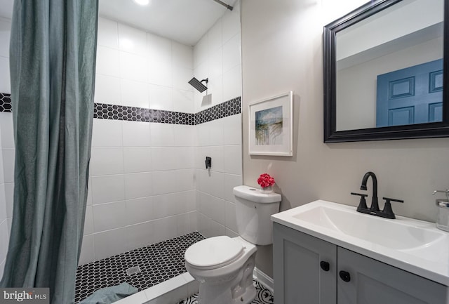 full bath featuring toilet, a stall shower, and vanity