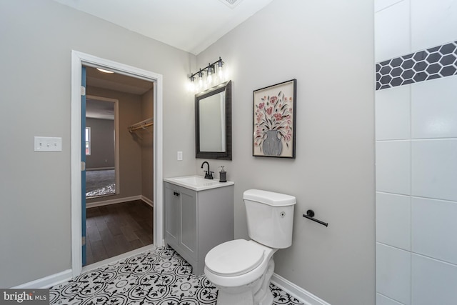 bathroom with tile patterned flooring, baseboards, vanity, and toilet