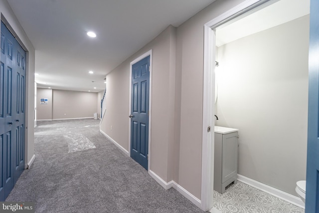 hall featuring baseboards, light carpet, and recessed lighting