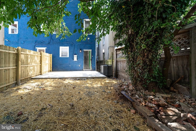 back of house with brick siding, a fenced backyard, and a patio