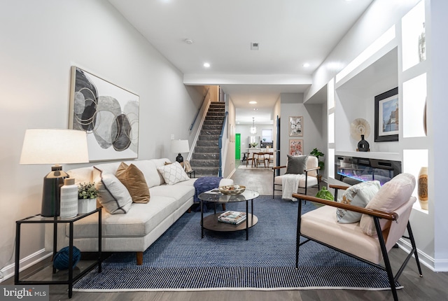 living room featuring dark wood-style floors, visible vents, stairway, and recessed lighting