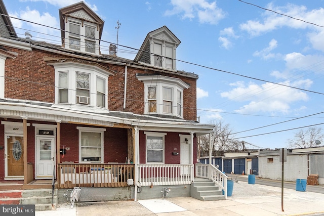 multi unit property featuring covered porch, brick siding, and a balcony