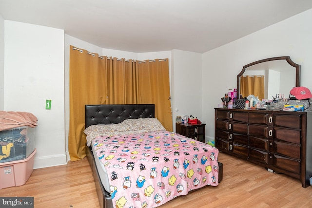 bedroom featuring baseboards and light wood finished floors