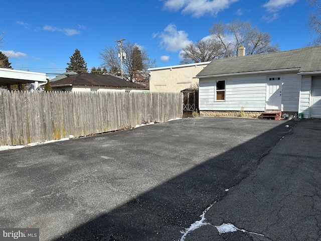 view of vehicle parking featuring entry steps and fence