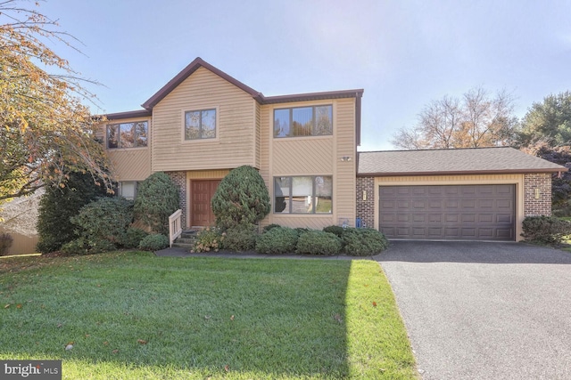 view of front of property with a garage, a front yard, and brick siding