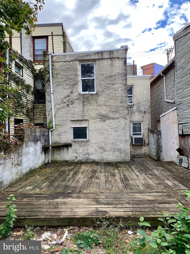 back of property featuring a deck and fence