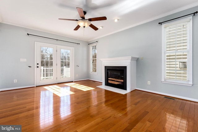 unfurnished living room with ornamental molding, visible vents, and hardwood / wood-style floors