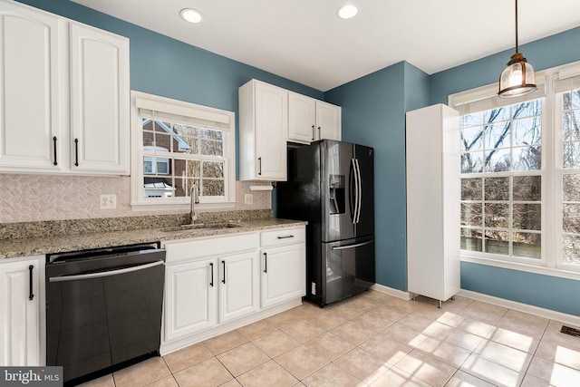 kitchen with a sink, backsplash, black appliances, and light stone countertops