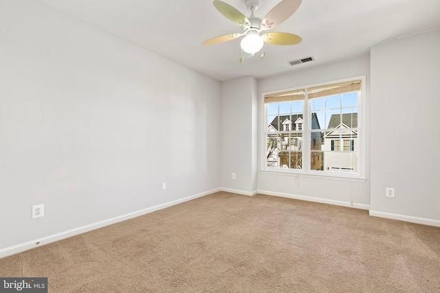 unfurnished room with a ceiling fan, carpet, visible vents, and baseboards