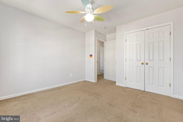 unfurnished bedroom featuring a closet, carpet, a ceiling fan, and baseboards