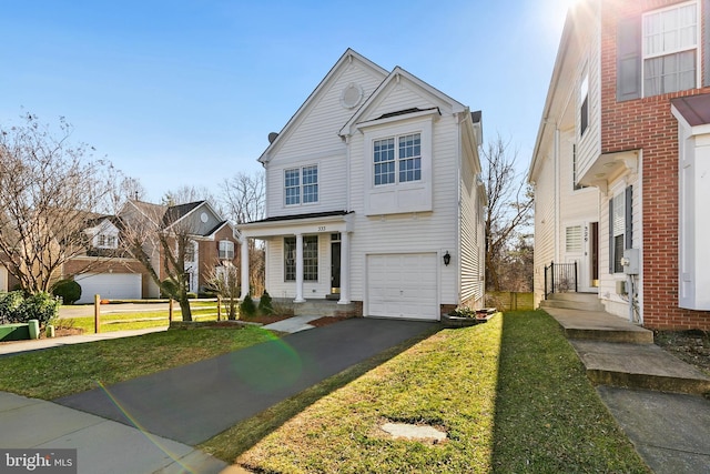 traditional-style home featuring aphalt driveway, a front lawn, and a garage