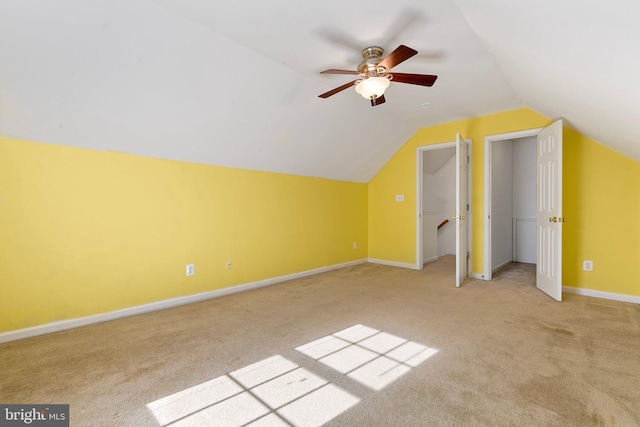 additional living space featuring lofted ceiling, light carpet, ceiling fan, and baseboards