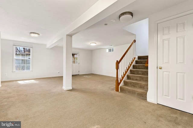 below grade area with stairway, carpet flooring, visible vents, and baseboards