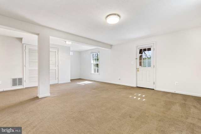 basement featuring carpet, visible vents, and baseboards