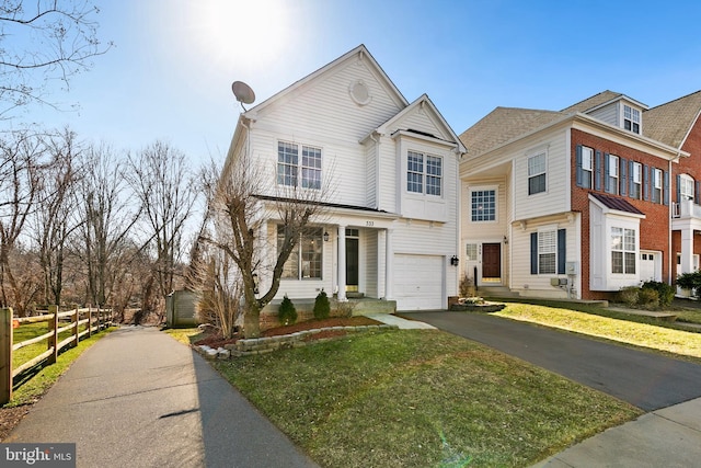 view of front of house featuring driveway, an attached garage, fence, and a front yard