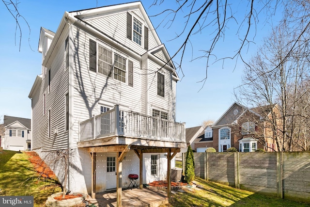 exterior space with central AC unit, a patio, fence, a deck, and brick siding