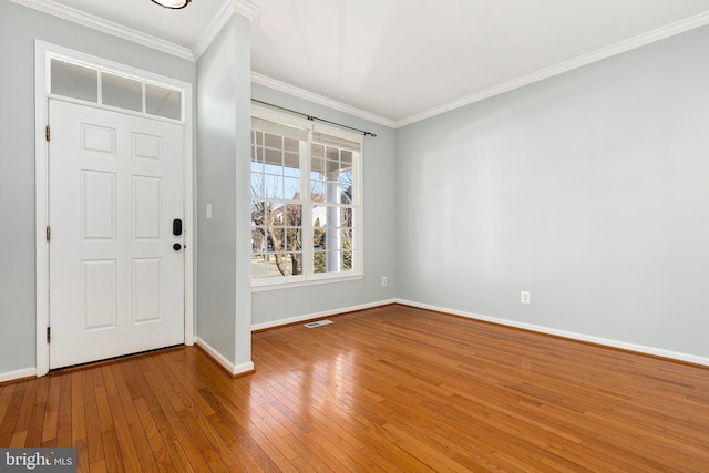 foyer entrance featuring visible vents, ornamental molding, hardwood / wood-style flooring, and baseboards