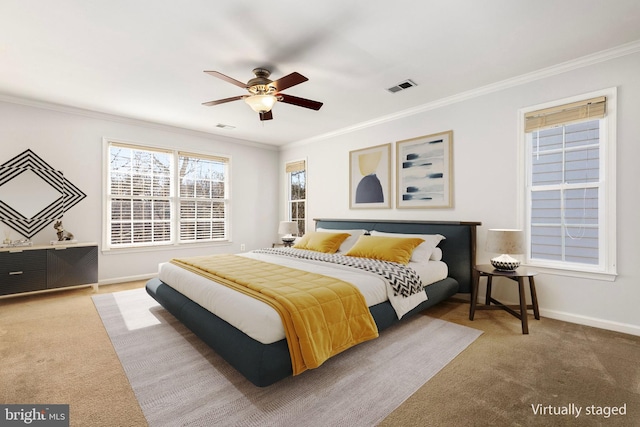 carpeted bedroom featuring ceiling fan, ornamental molding, visible vents, and baseboards