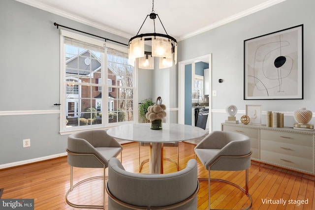 dining space with baseboards, wood-type flooring, a chandelier, and crown molding