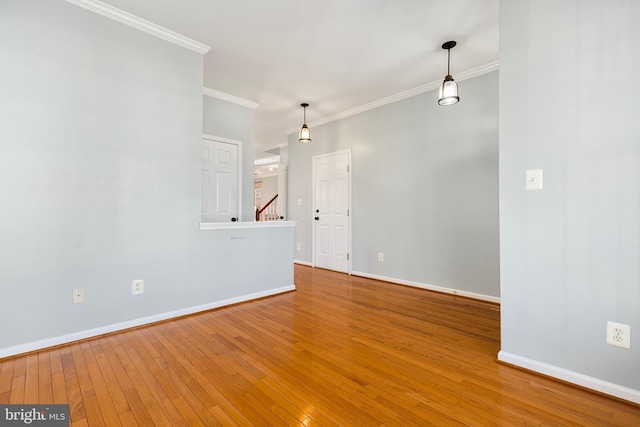 unfurnished room with hardwood / wood-style flooring, stairs, baseboards, and crown molding