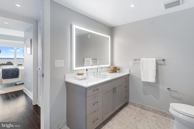 ensuite bathroom with marble finish floor, baseboards, visible vents, and ensuite bathroom