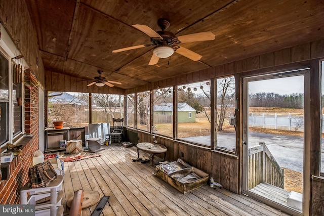 unfurnished sunroom with a water view, wood ceiling, and a ceiling fan