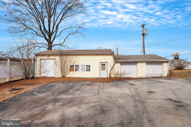 exterior space with a garage, an outdoor structure, and fence