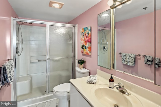 bathroom featuring a stall shower, vanity, and toilet