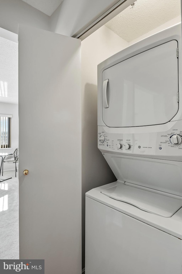 laundry room with stacked washing maching and dryer and laundry area