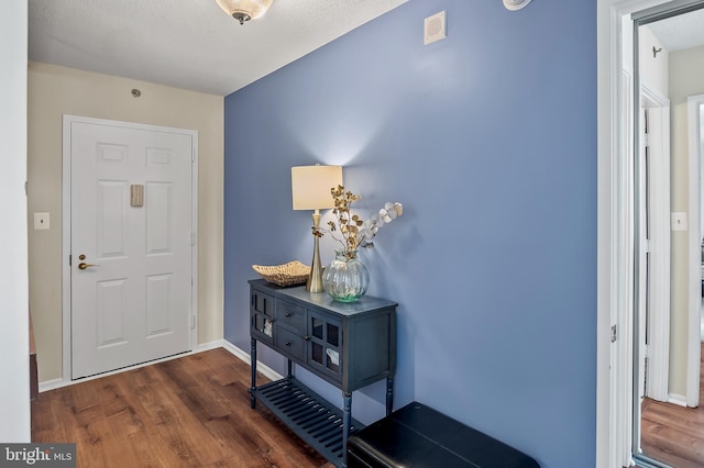 entrance foyer with visible vents, baseboards, and wood finished floors