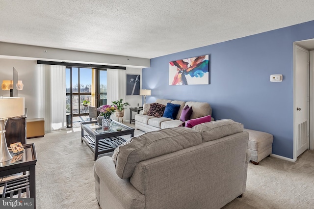 living room featuring visible vents, a textured ceiling, and light colored carpet