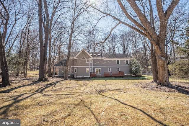 back of property featuring a lawn and a wooden deck