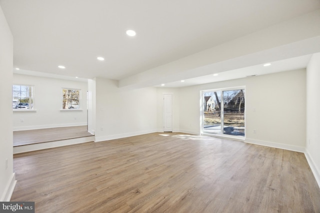 unfurnished living room with baseboards, light wood finished floors, and recessed lighting