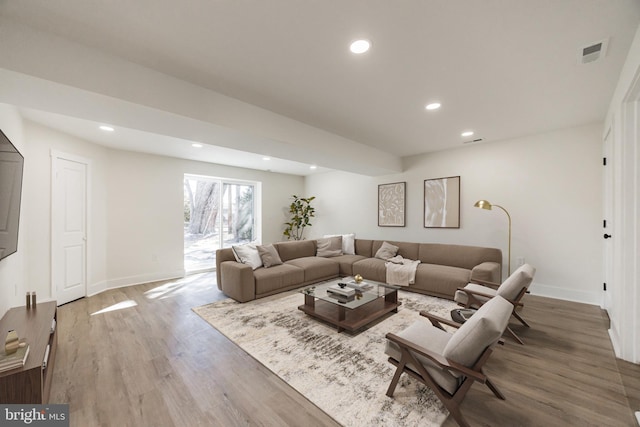 living room with baseboards, visible vents, wood finished floors, and recessed lighting