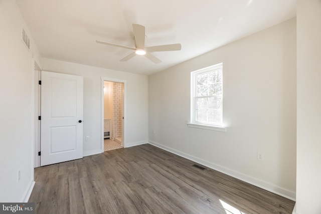 unfurnished bedroom featuring visible vents, baseboards, and wood finished floors