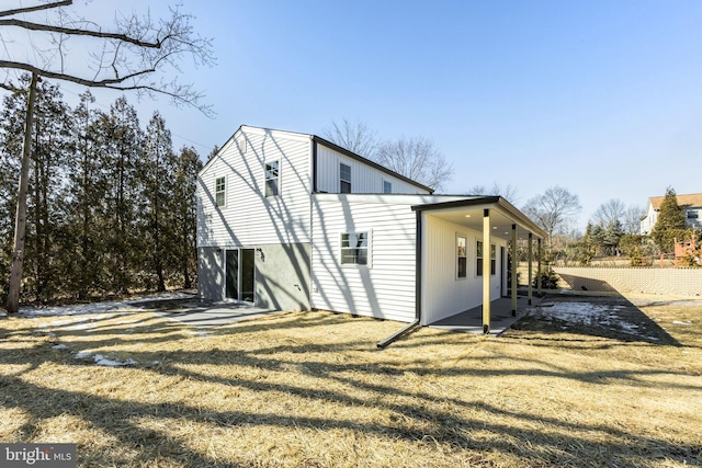 view of side of home with a patio area and a lawn